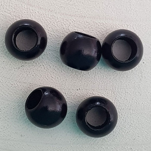 Cinq perles rondes en bois noir pour bijoux.