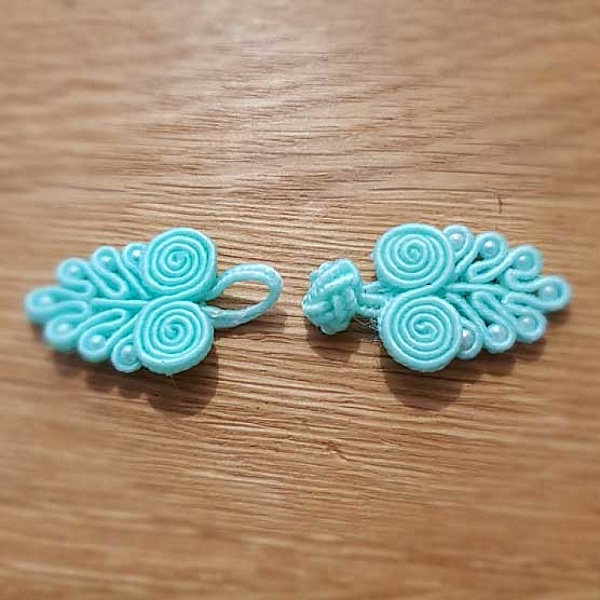 Bouton brandebourg style chinois bleu clair en passementerie.