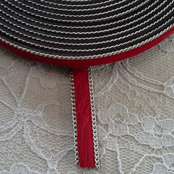Lanière en cuir rouge plat avec chaîne argentée.