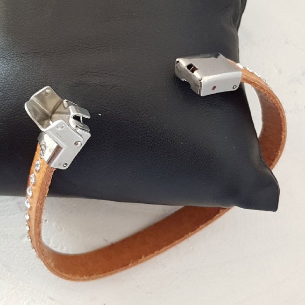 Bracelet en cuir marron avec fermoir métallique et strass.
