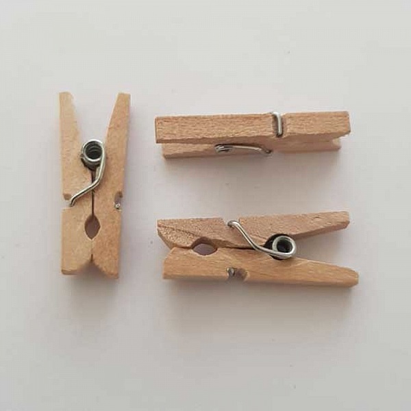 Lot de trois mini pinces à linge en bois naturel.