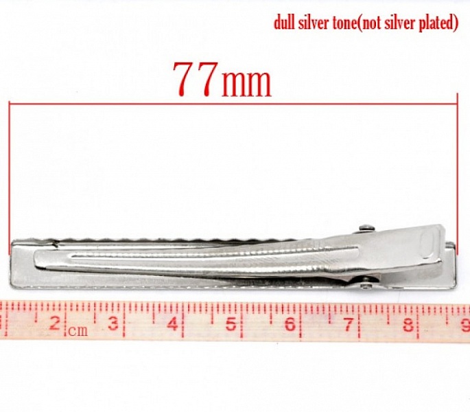 Pince barrette crocodile argentée de 77 mm de longueur.