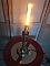 Lampe bougie ancienne en laiton style Edison allumée.