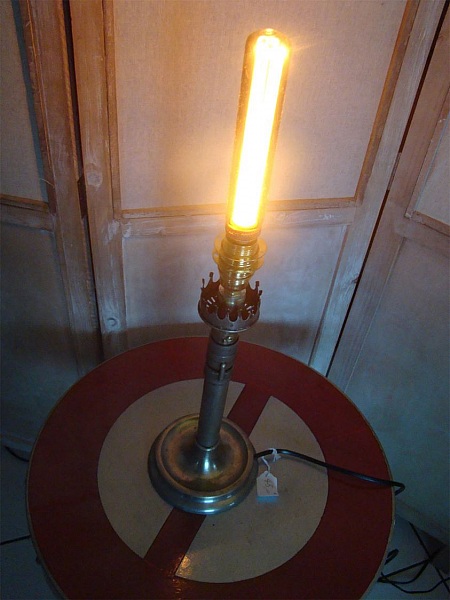 Lampe bougie ancienne en laiton style Edison allumée.