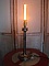 Lampe bougie ancienne en laiton avec ampoule Edison allumée.