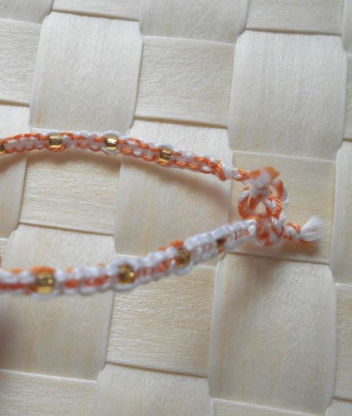 Tour de poignet en macram&eacute; corail blanc avec perles de rocaille dor&eacute;es 