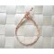 Tour de poignet en macram&eacute; corail blanc avec perles de rocaille dor&eacute;es 