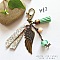Porte cl&eacute; ou bijou de sac avec pendentif aile d'ange couleur bronze dans les tons pastels tendres