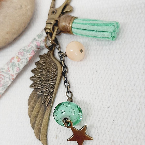 Porte cl&eacute; ou bijou de sac avec pendentif aile d'ange couleur bronze dans les tons pastels tendres