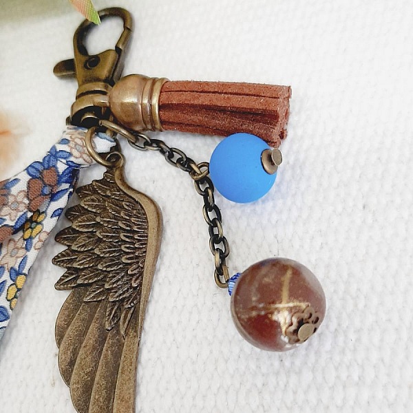 Porte-clé bijou de sac avec aile d'ange bronze et perles.