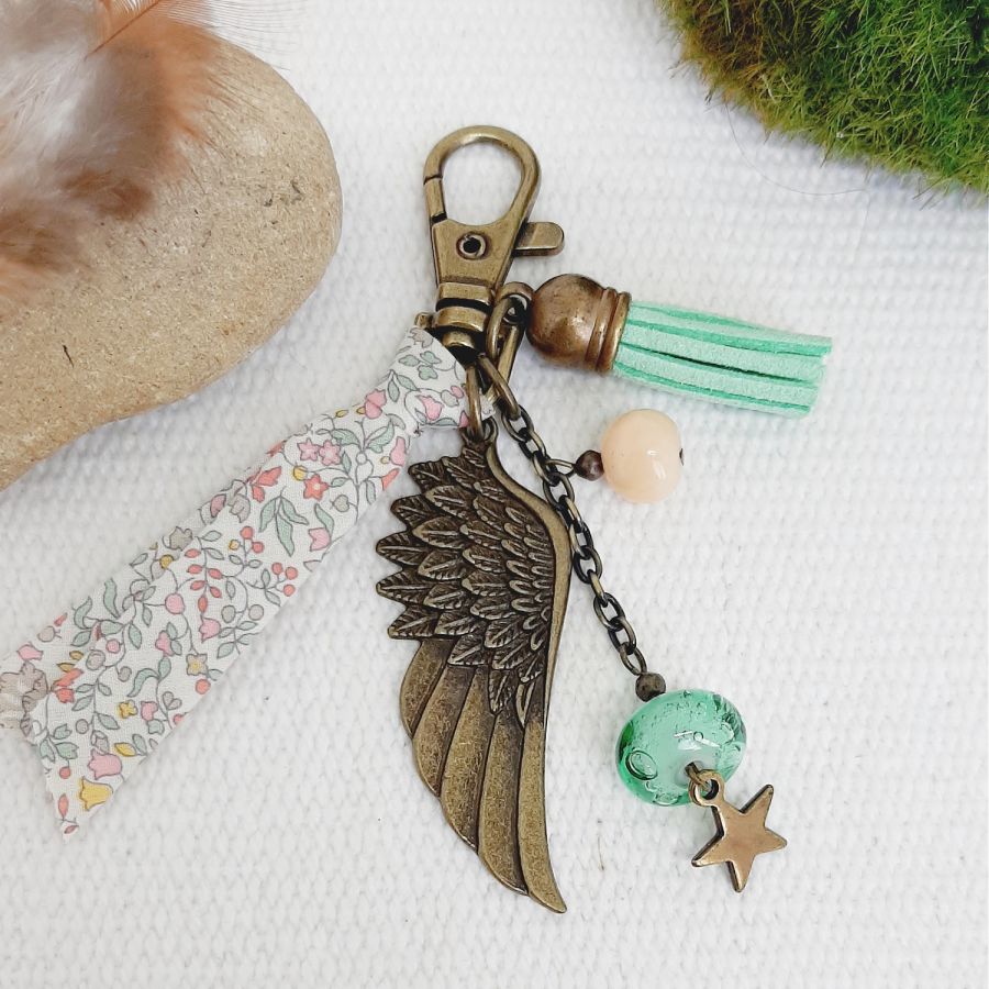 Porte cl&eacute; ou bijou de sac avec pendentif aile d'ange couleur bronze dans les tons pastels tendres