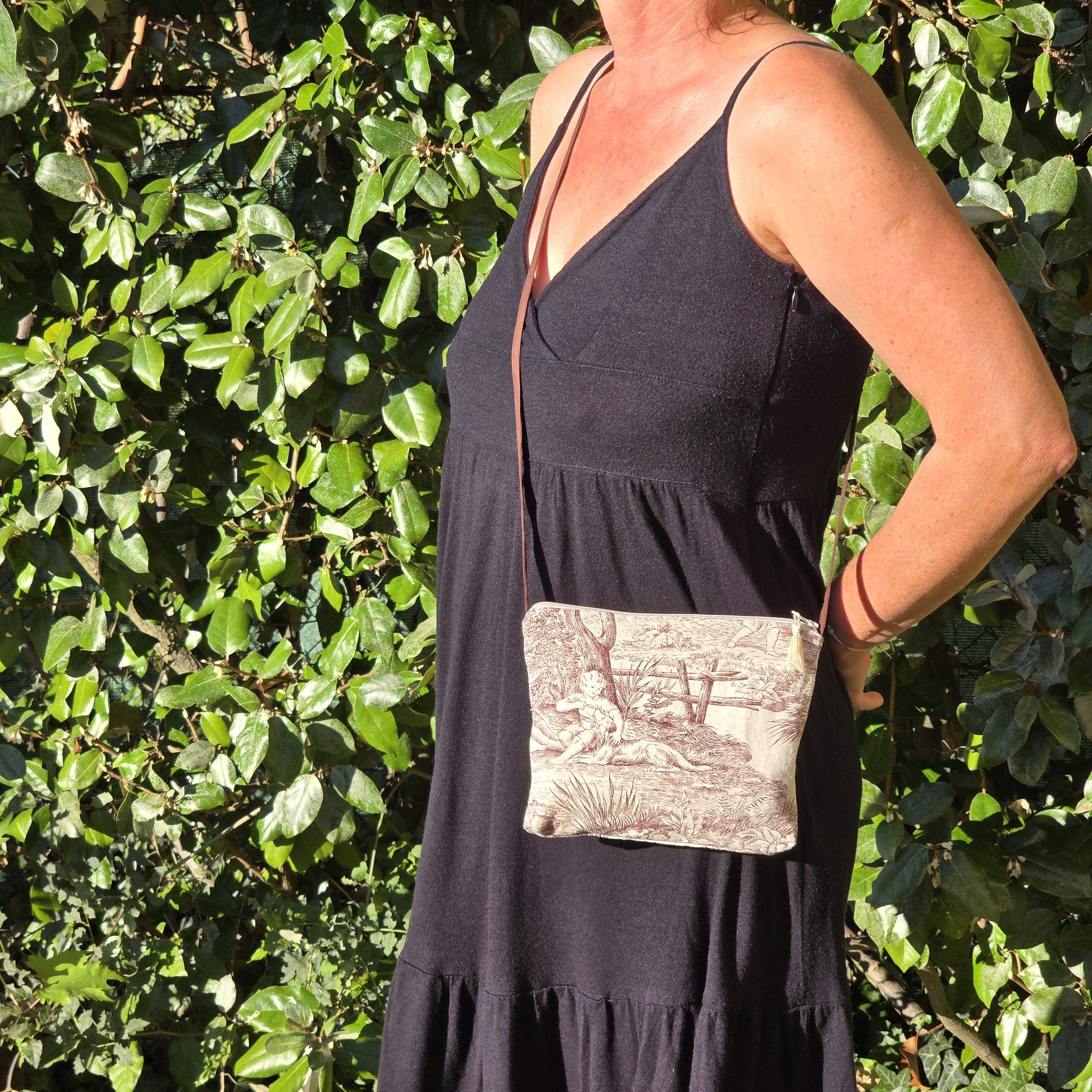 Pochette avec bandouli&egrave;re en tissu toile de Jouy marron et beige agr&eacute;ment&eacute;e d'un pompon