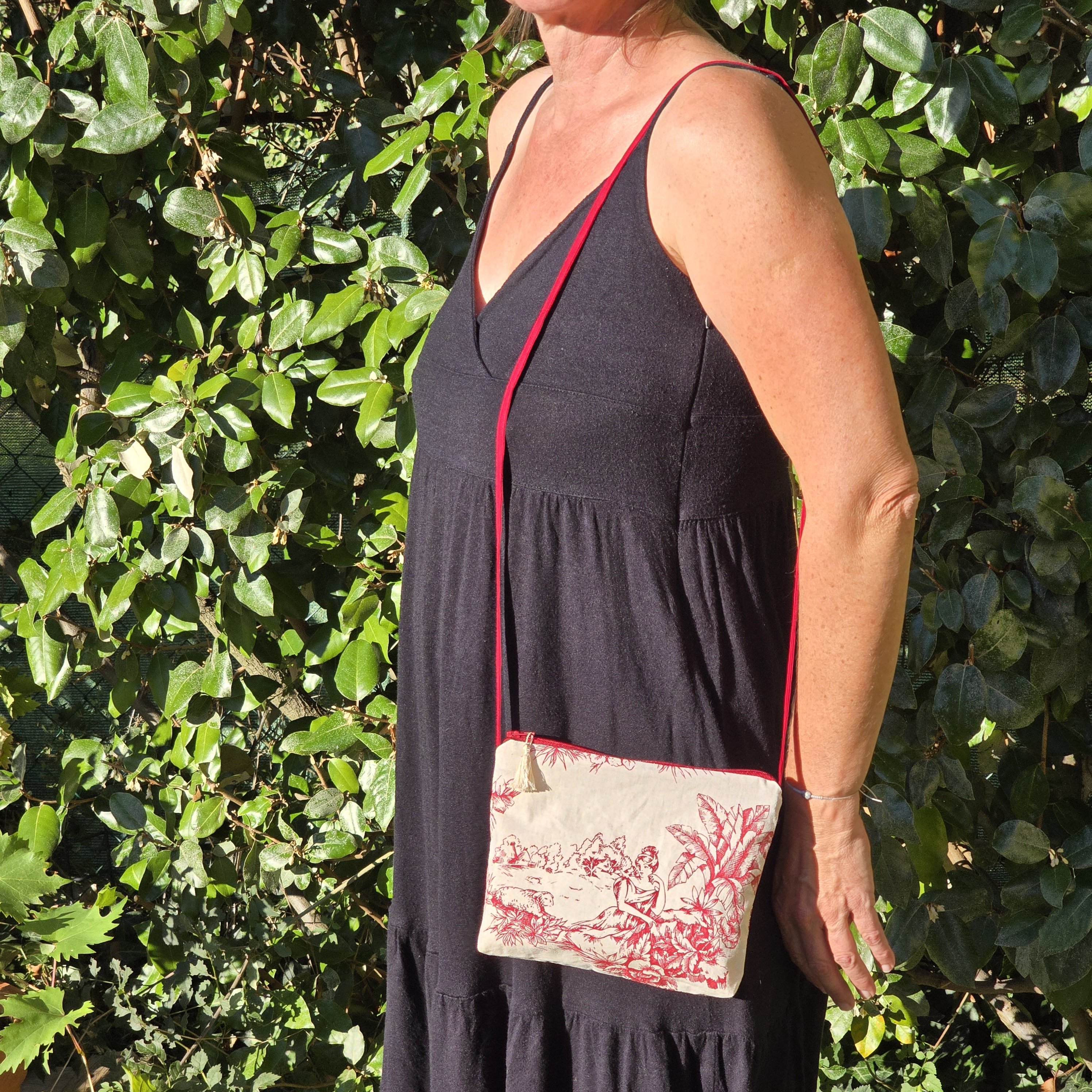 Pochette avec bandouli&egrave;re en tissu toile de Jouy bordeaux et &eacute;cru agr&eacute;ment&eacute;e d'un pompon