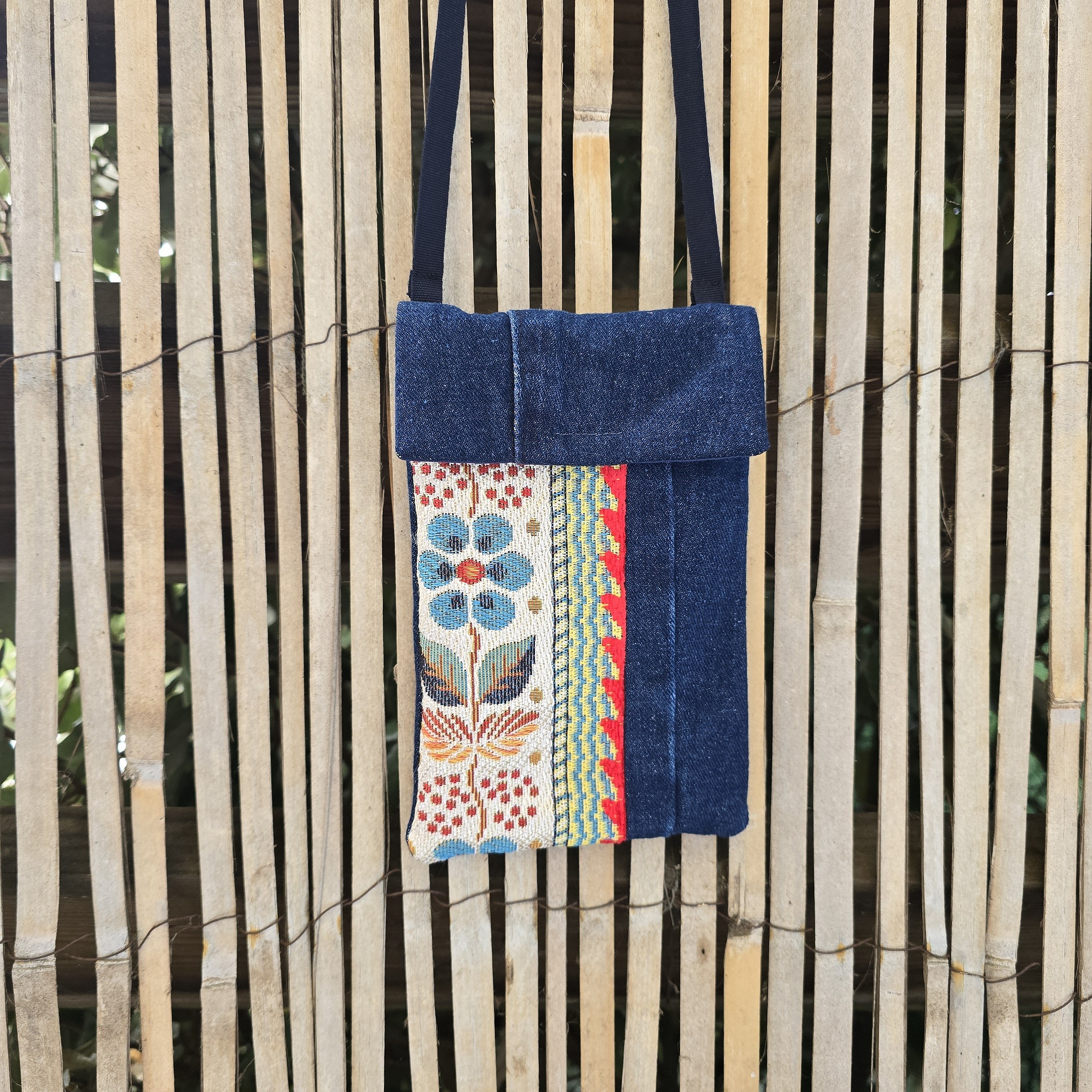 Pochette téléphone en jean recyclé avec bandoulière et motif floral.