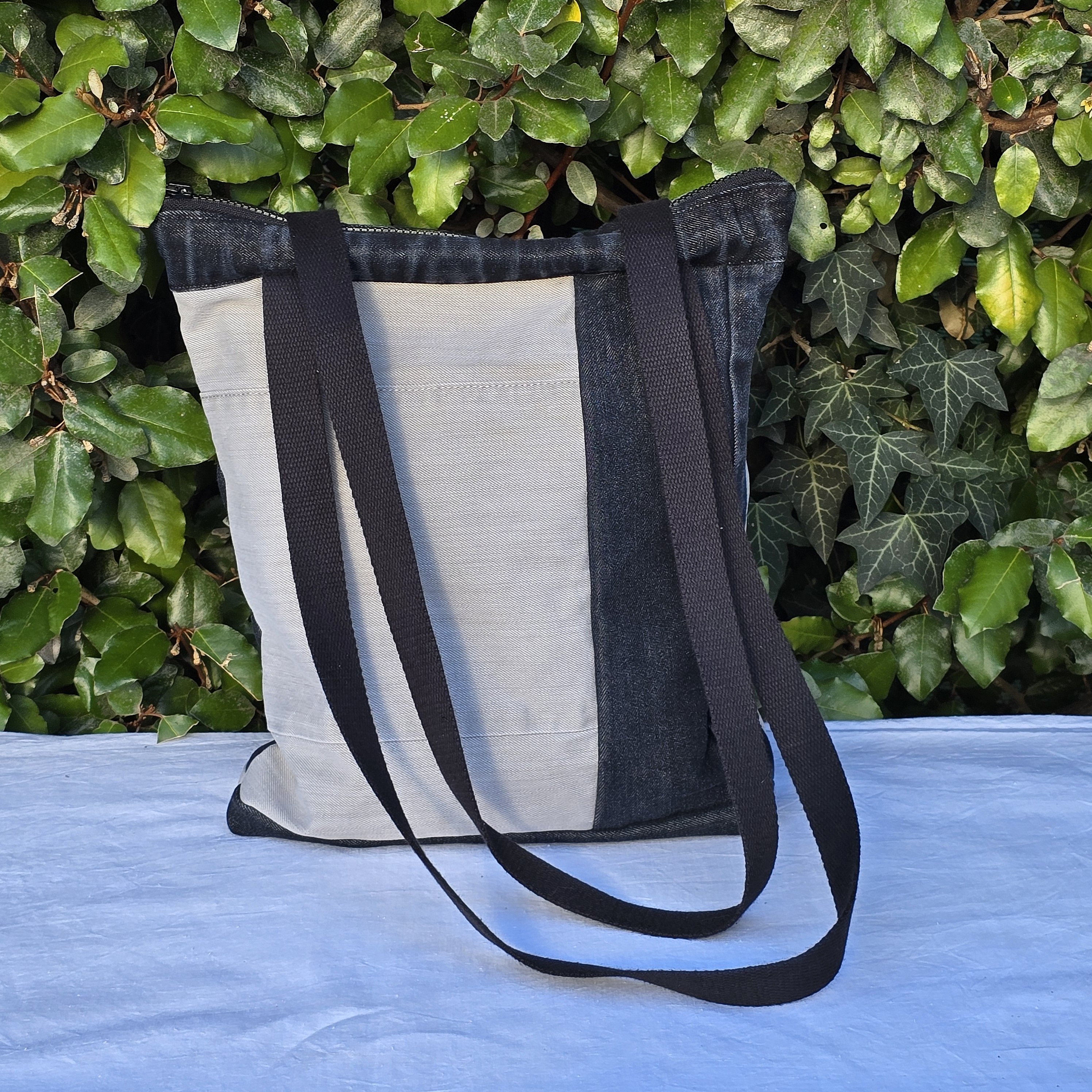 Sac à bandoulière en jean recyclé noir et gris.