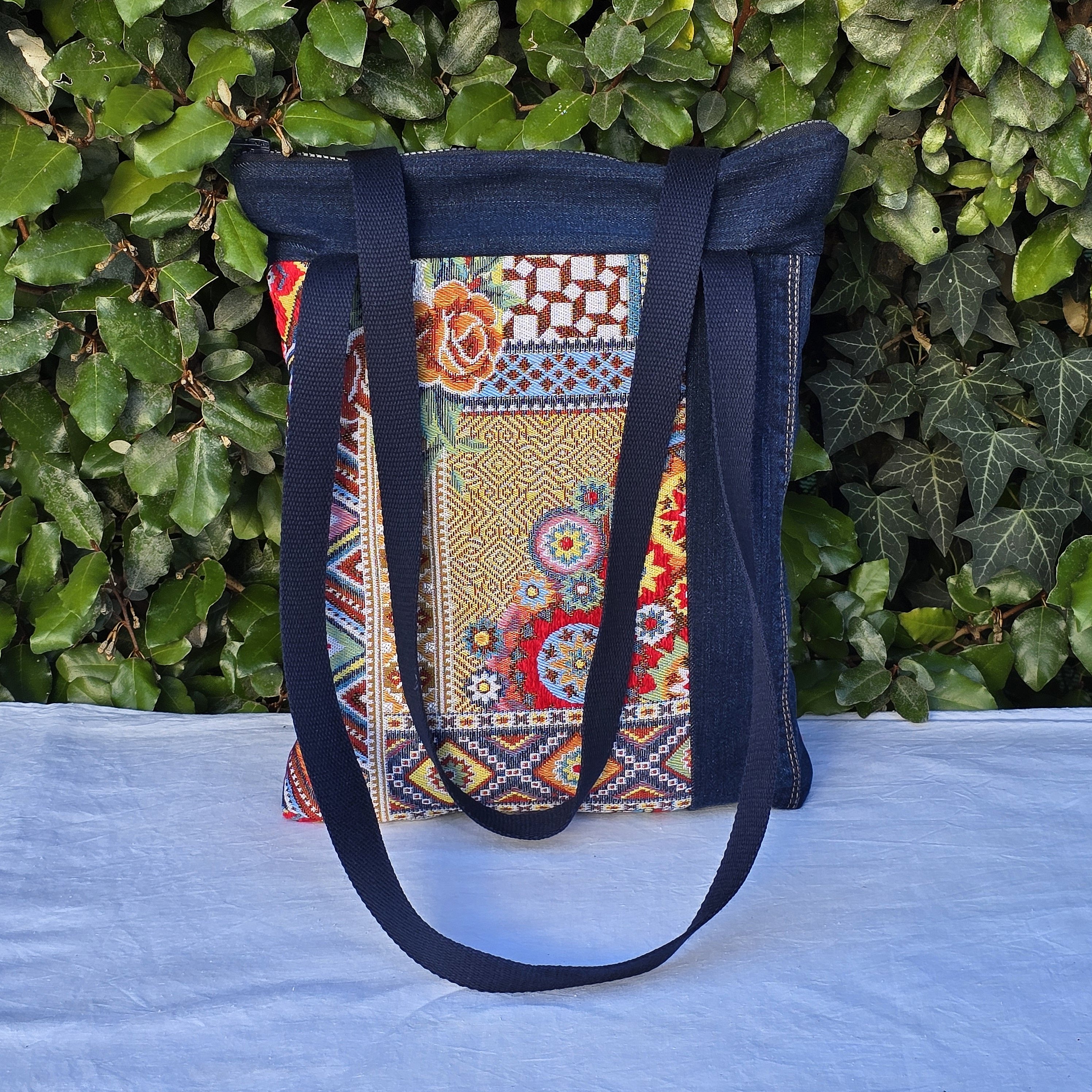 Sac à bandoulière en jean recyclé avec empiècements colorés.