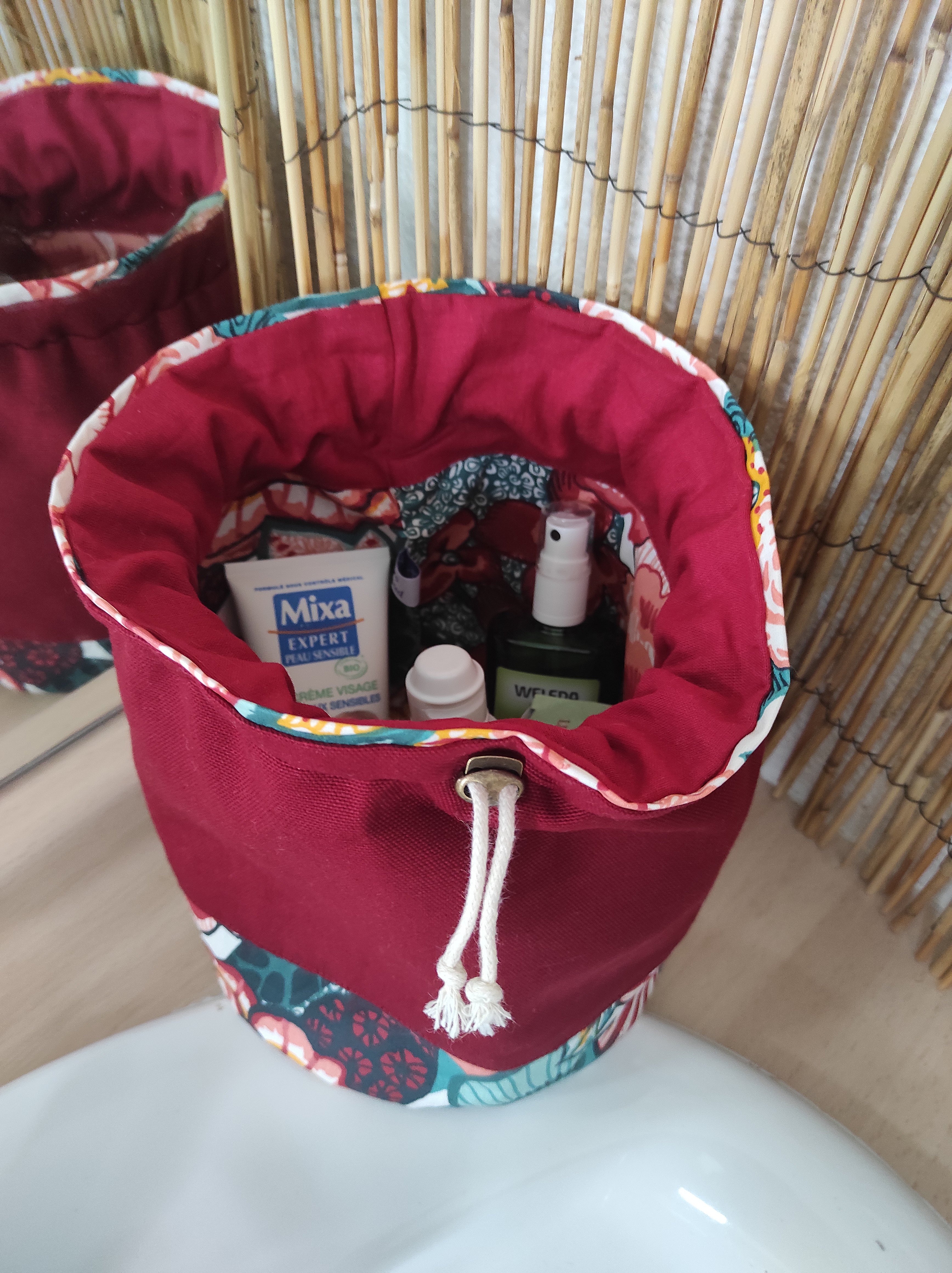 Trousse de toilette bourse imperméable à motifs floraux bordeaux.