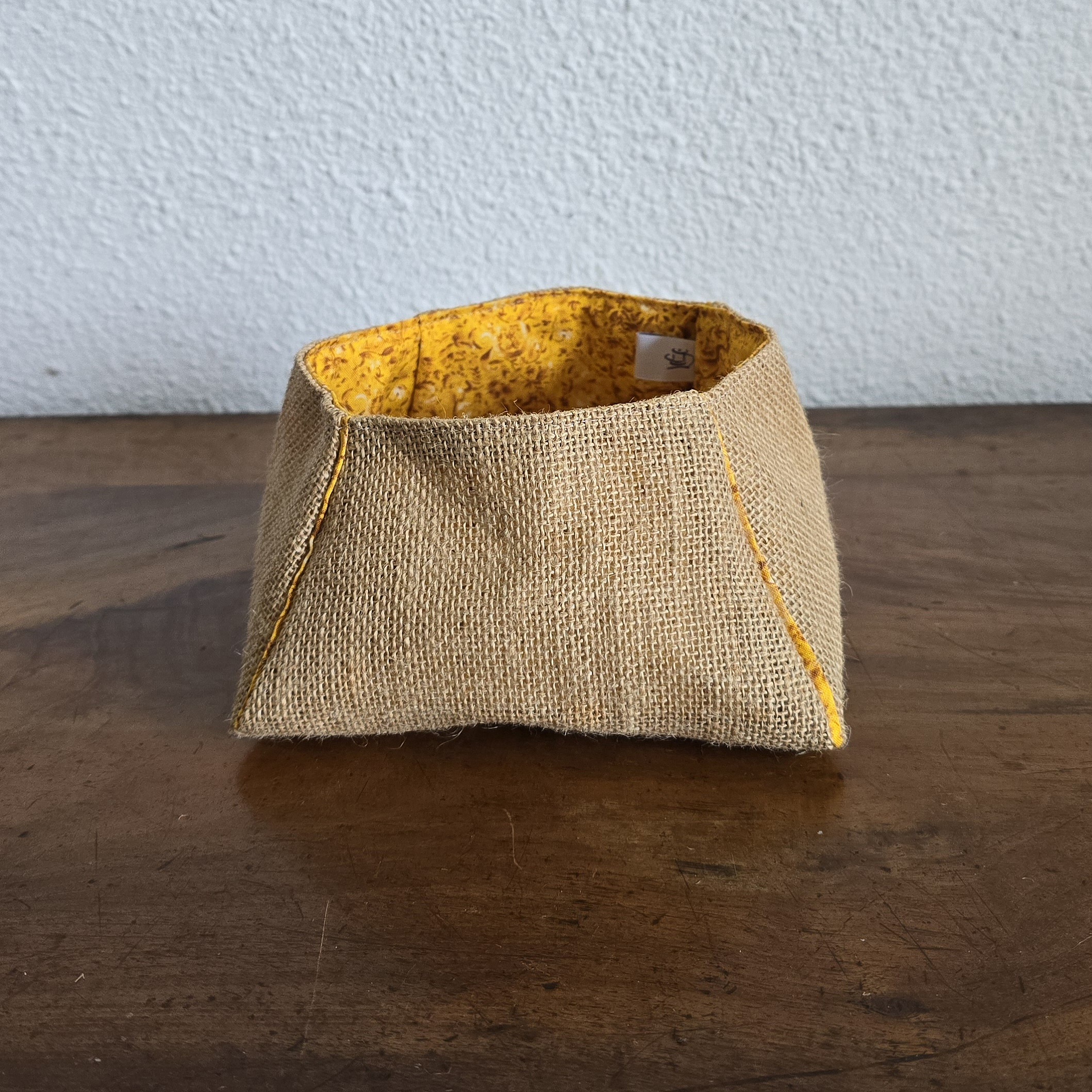 Vide-poche trapèze en toile de jute avec intérieur jaune.