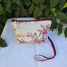 Pochette avec bandouli&egrave;re en tissu toile de Jouy bordeaux et &eacute;cru agr&eacute;ment&eacute;e d'un pompon