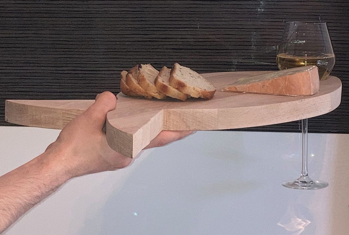 Planche apéro en bois forme poisson avec verre et pain.