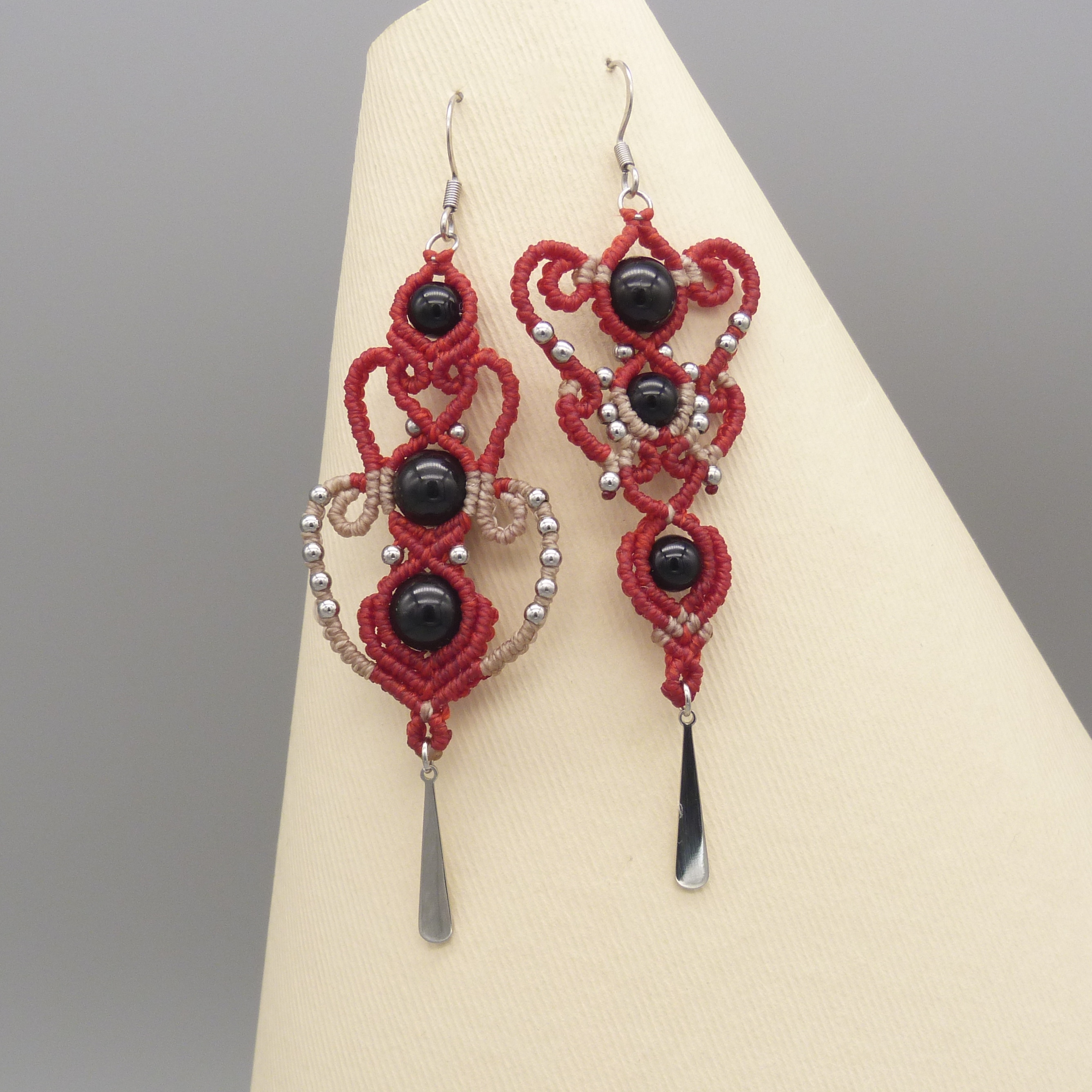 Boucles d'oreilles  en micro-macram&eacute; rouges et beiges avec perles en onyx noir