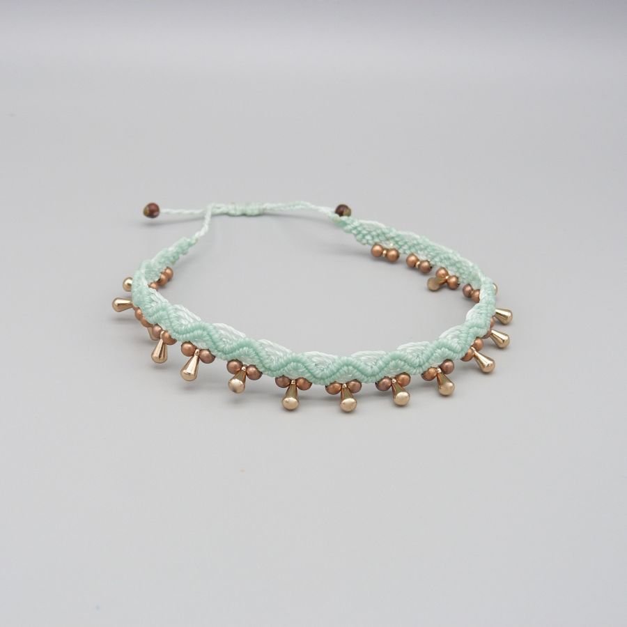 Bracelet de cheville en micro-macramé vert menthe à perles dorées.