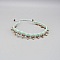 Bracelet de cheville en micro-macramé vert menthe à perles dorées.