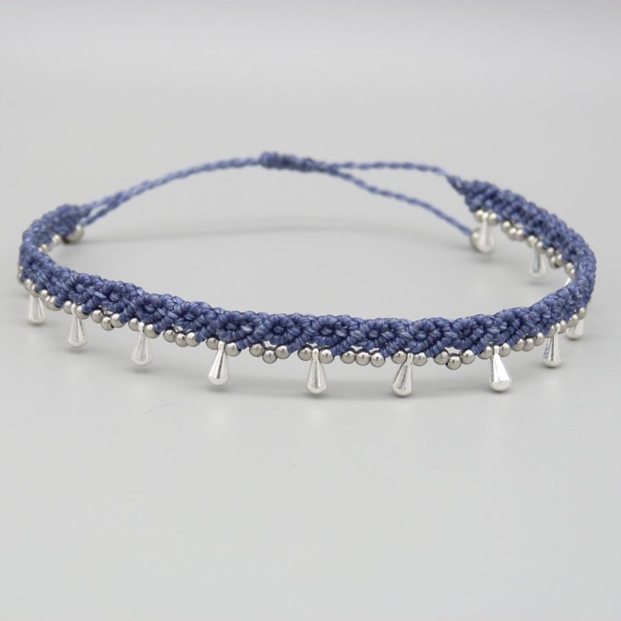 Bracelet de cheville en micro-macramé bleu avec perles argentées.