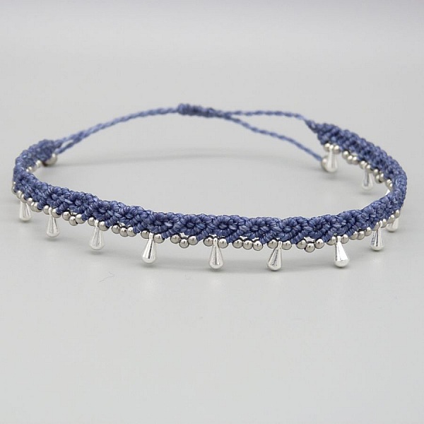 Bracelet de cheville en micro-macramé bleu avec perles argentées.