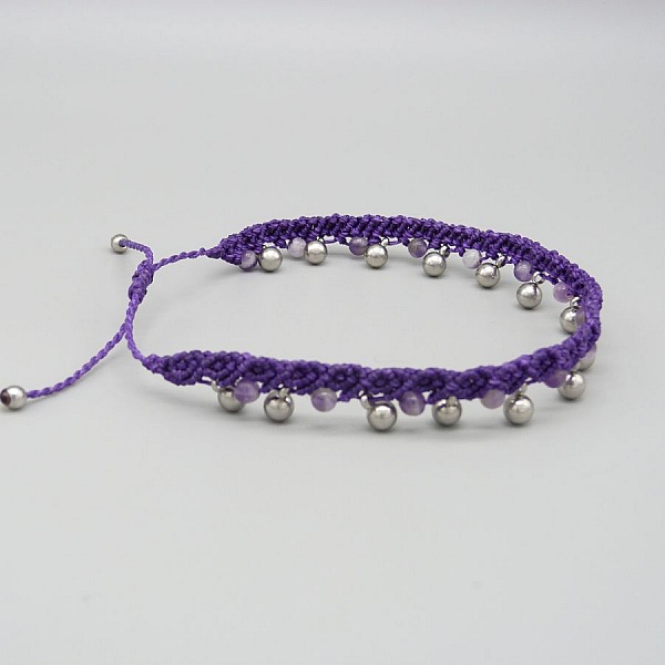 Bracelet de cheville en micro-macramé violet avec perles argentées.