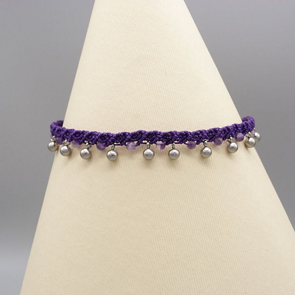 Bracelet de cheville en micro-macramé violet avec perles argentées.