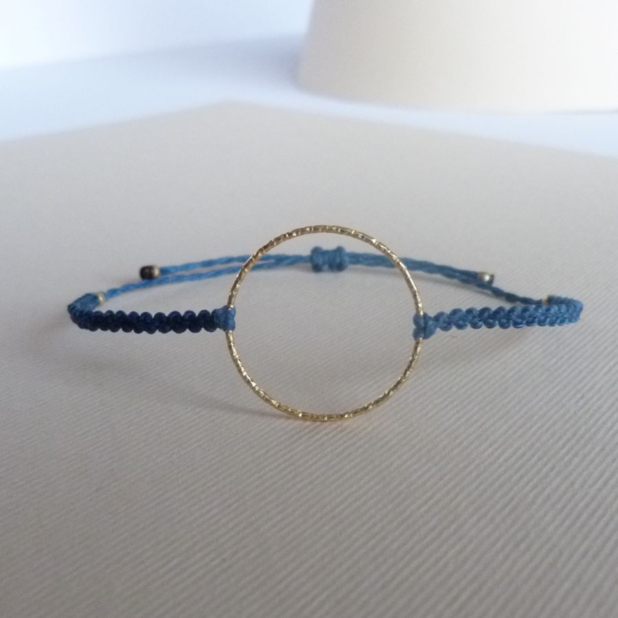 Bracelet fin en micro-macramé bleu avec anneau doré.