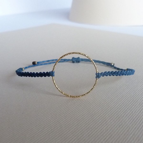 Bracelet fin en micro-macramé bleu avec anneau doré.
