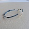 Bracelet fin en micro-macramé bleu avec anneau doré.