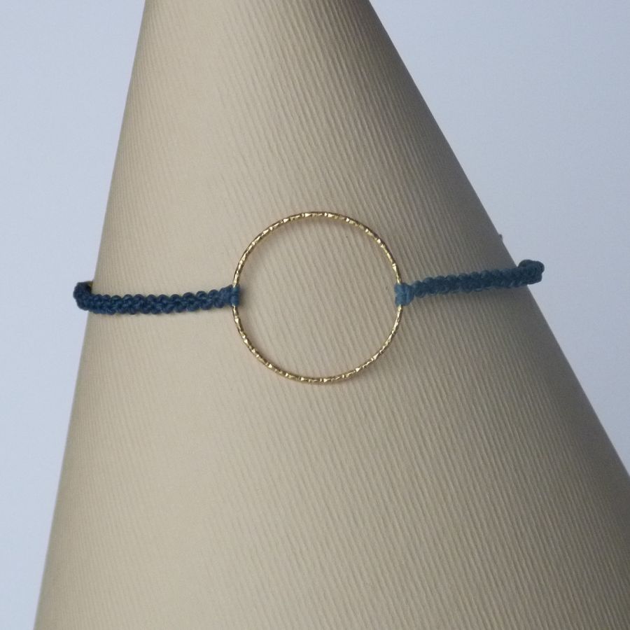 Bracelet fin en micro-macramé bleu avec anneau doré.