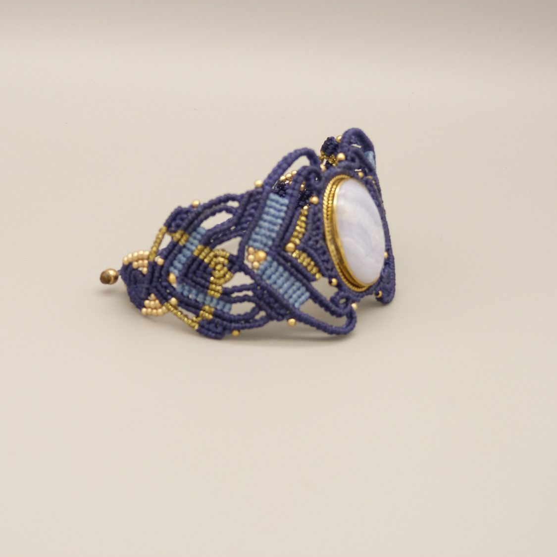Bracelet en micro-macram&eacute; bleu nuit avec une agate ruban&eacute;e sertie de m&eacute;tal dor&eacute;