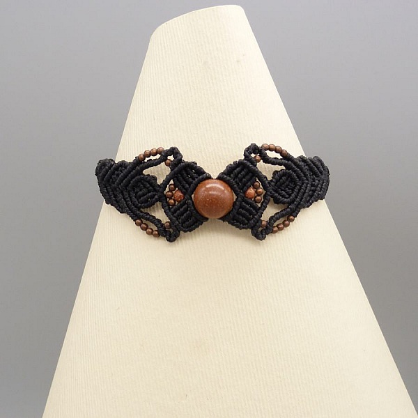 Bracelet en micro-macram&eacute; noir avec une perle centrale "pierre de soleil"