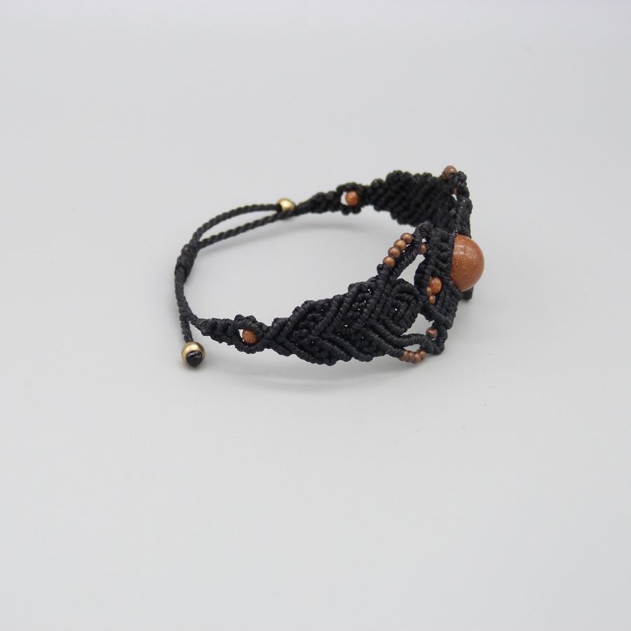 Bracelet en micro-macram&eacute; noir avec une perle centrale "pierre de soleil"