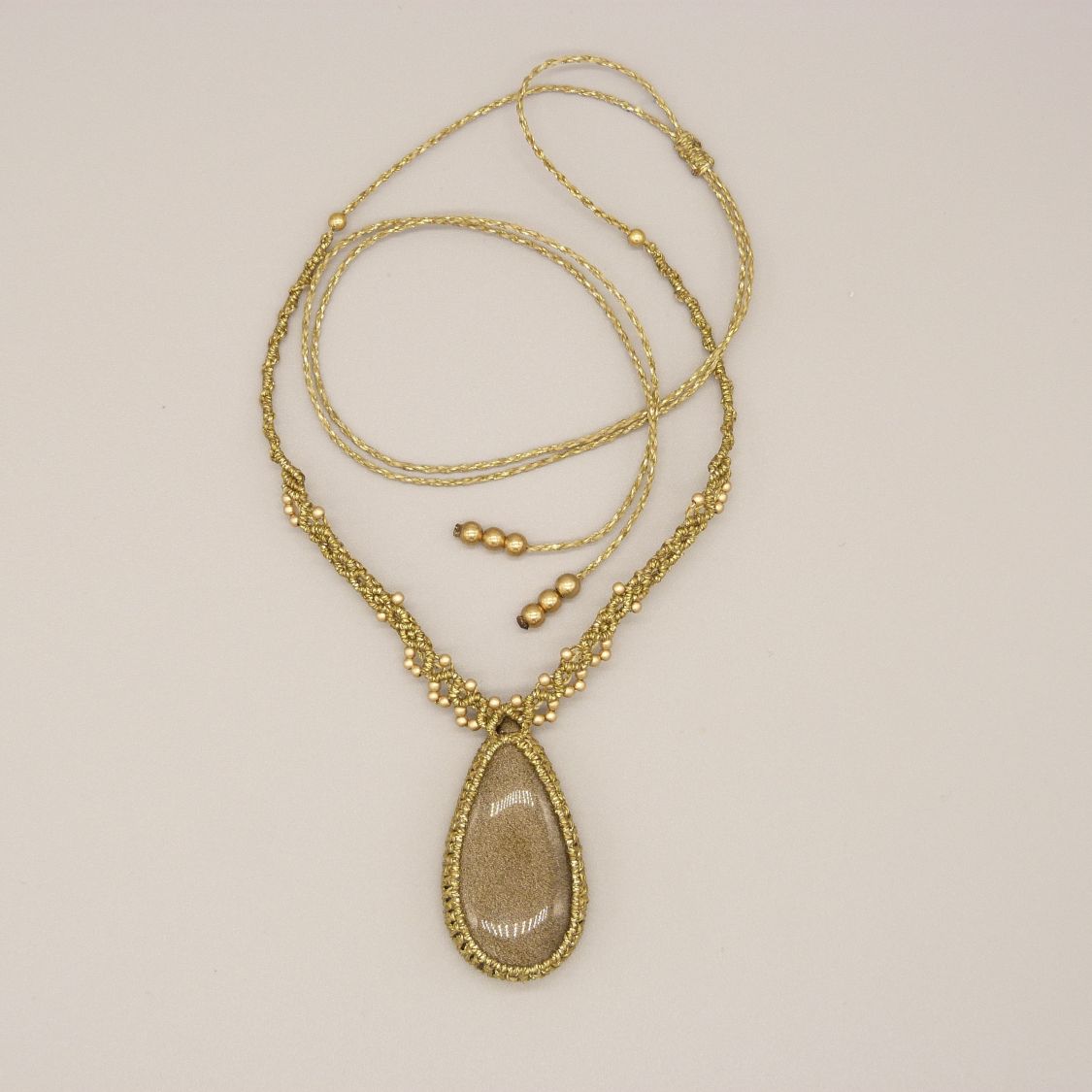 Collier  micro-macram&eacute; dor&eacute; avec une  obsidienne dor&eacute;e 