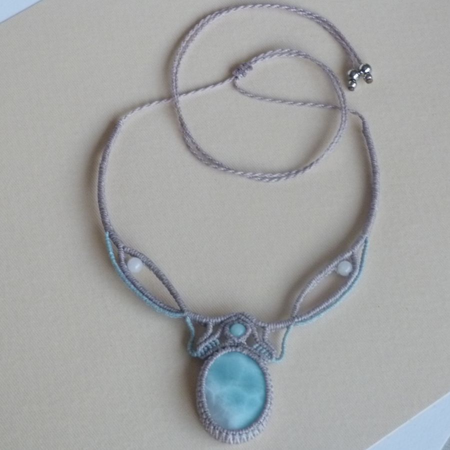 Collier en micro-macram&eacute; gris taupe/bleu givr&eacute; avec en pi&egrave;ce centrale une pierre gemme naturelle aux douces nuances de blanc et de bleu clair.
