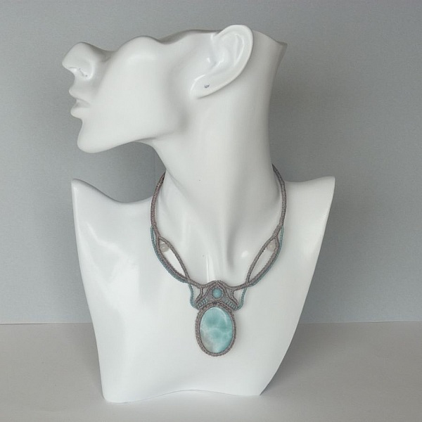 Collier en micro-macram&eacute; gris taupe/bleu givr&eacute; avec en pi&egrave;ce centrale une pierre gemme naturelle aux douces nuances de blanc et de bleu clair.