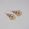 Paire de boucles d'oreilles couleur paille en micro-macram&eacute; avec un oeil de tigre