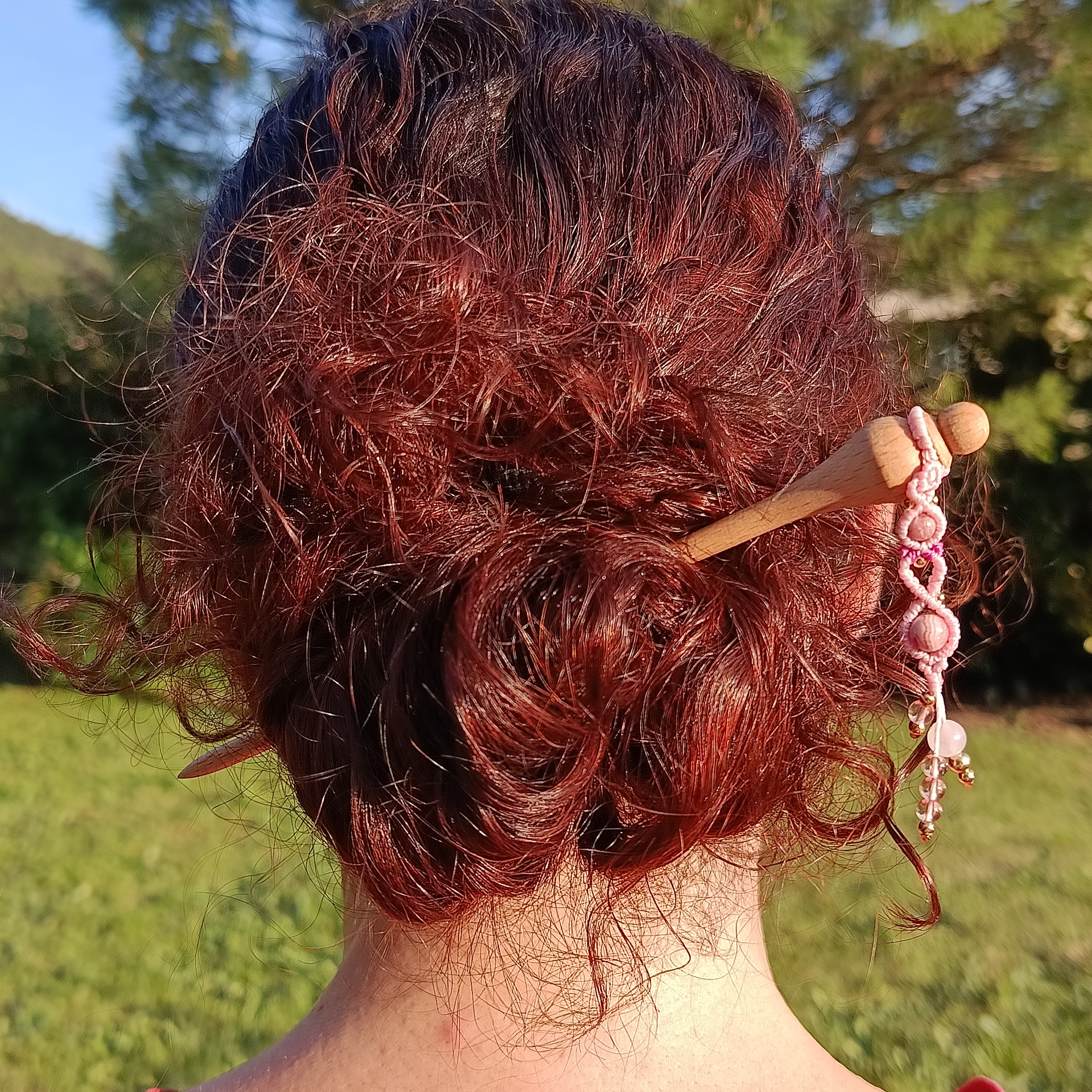 Pic à cheveux en hêtre avec ornement micro-macramé rose.