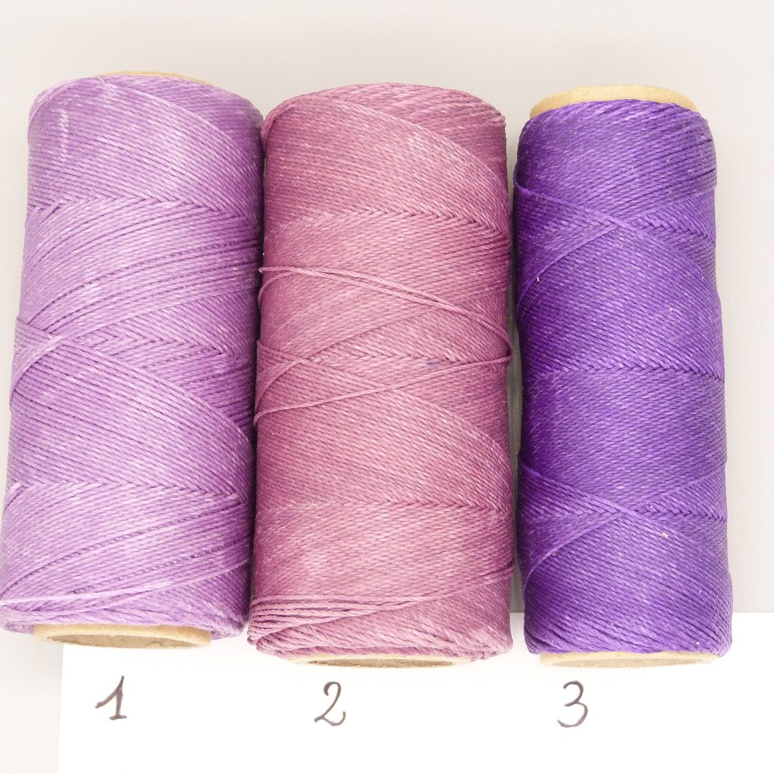 Trois bobines de fil violet pour personnaliser vos porte-clefs.