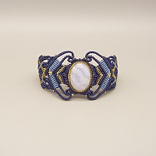 Bracelet en micro-macram&eacute; bleu nuit avec une agate ruban&eacute;e sertie de m&eacute;tal dor&eacute;