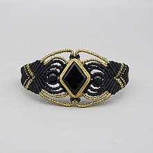 Manchette noire en micro-macram&eacute; avec une pierre onyx noire sertie de laiton