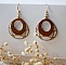 Boucles d'oreilles ailes en bois merisier sur ovale ajour&eacute; en laiton dor&eacute;