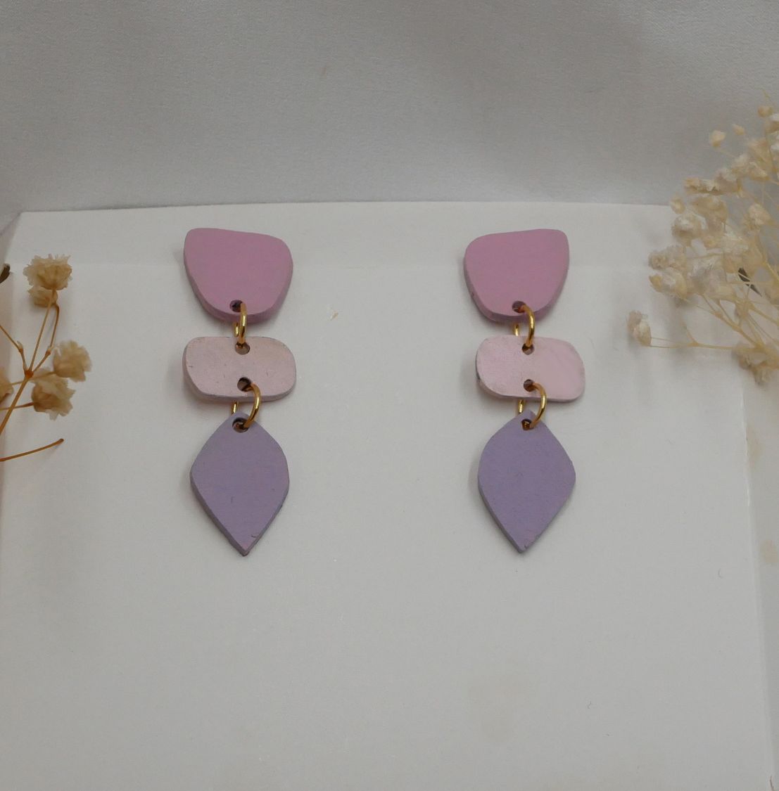 Boucles d'oreilles pendantes en bois aux tons pastel.