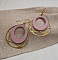 Boucles d'oreilles bois rose pastel sur ovale ajouré doré.