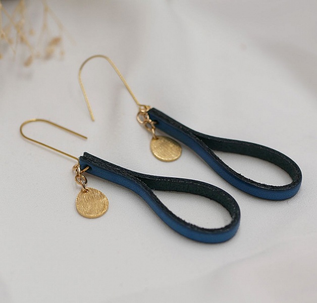 Boucles d'oreilles pendantes en cuir bleu et pampilles dorées.